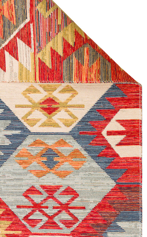 Load image 1 in gallery view. Ethnic Mix - Kilim - NMD01: A multicolour rug with geometric diamond and zigzag patterns in red, blue, yellow, and orange; one corner is folded to show vivid tribal motifs beneath.