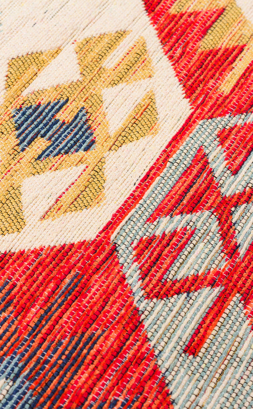 Load image 1 in gallery view. Close-up of the "Ethnic Mix - Kilim - NMD01" rug, featuring multicolour geometric patterns and tribal motifs in red, yellow, blue, and cream with visible texture and intricate stitching.