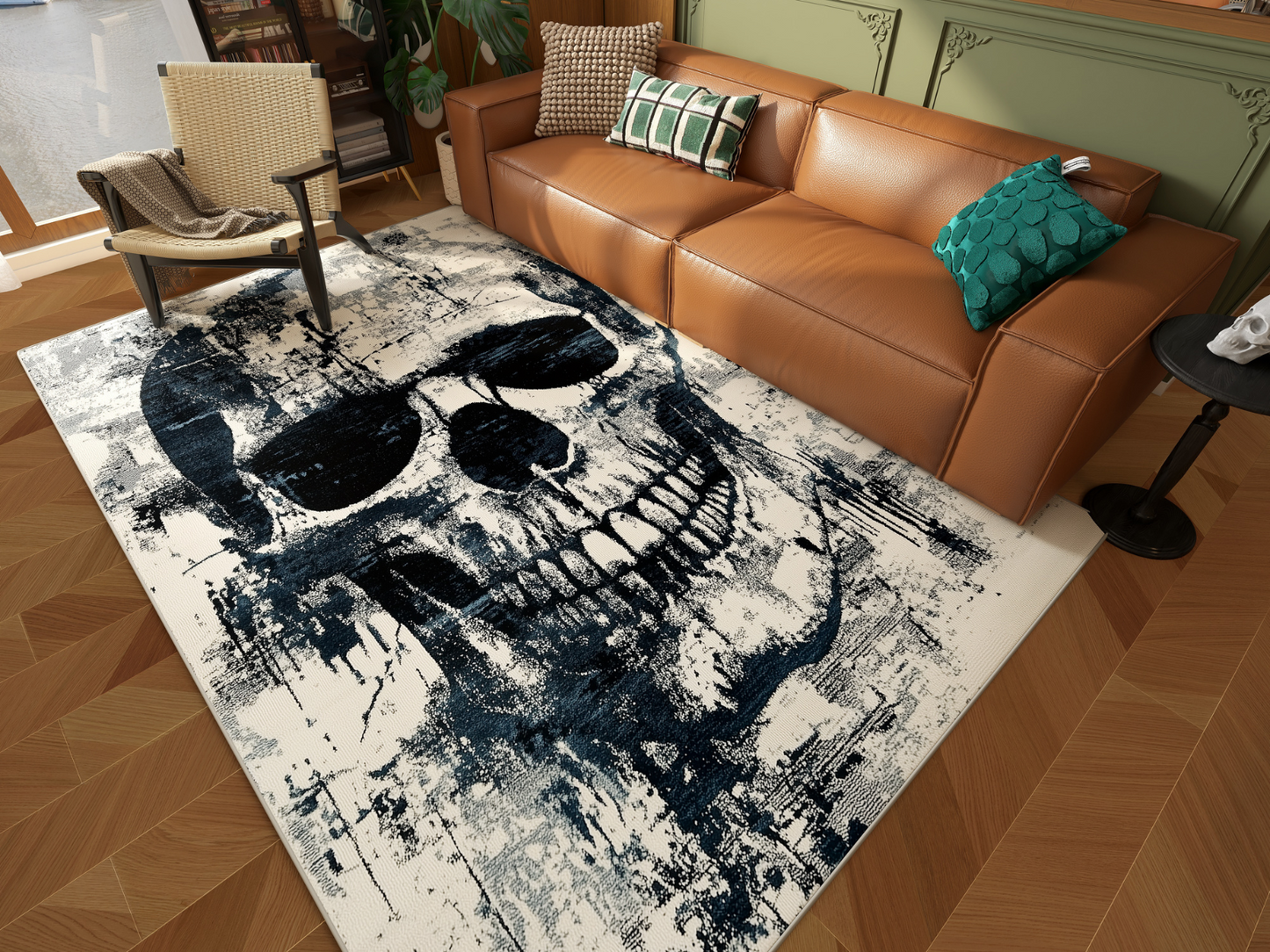 A modern living room with a brown leather sofa, green pillows, and the Faded Skull - Washable Rug - HLW008, featuring a large artistic black skull on white. A woven chair and plants complete the cozy, eclectic decor.