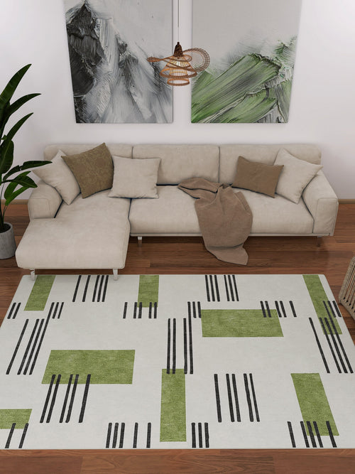 Load image 1 in gallery view. Modern living room with a beige sectional, green and brown pillows, a taupe throw, abstract wall art, a potted plant, and the Faded Treasure - Washable Rug - JRN46 featuring green blocks and black lines on a white background.