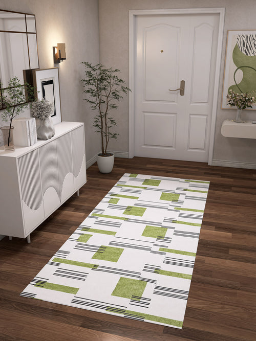 Load image 1 in gallery view. A modern hallway with wood flooring, a white sideboard, potted plant, abstract art, and the Faded Treasure - Washable Rug - JRN46 leading to a white front door with gold hardware.