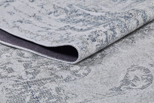 Load image 1 in gallery view. A close-up of the Faint Memories - Washable Rug - JR1437 (Custom Size), folded to display its light gray flat weave, subtle distressed dark gray pattern on a light background, highlighting texture and weave detail.