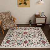 A cozy room with a zebra-print armchair, the Floral Ivory - Washable Rug - JRN1025 (Custom Size) featuring red, green, and blue florals—ideal for high-traffic areas—a small plant, a wooden cabinet with books and vase, and a wall lamp under botanical art.