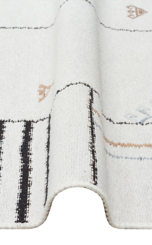 Bild 1 in Galerieansicht laden. A close-up of the Fog Detail - Washable Double-Sided Kilims - AR40, a white reversible rug featuring black, tan, and blue geometric designs with a textured wave—crafted from recycled cotton for sustainable style.