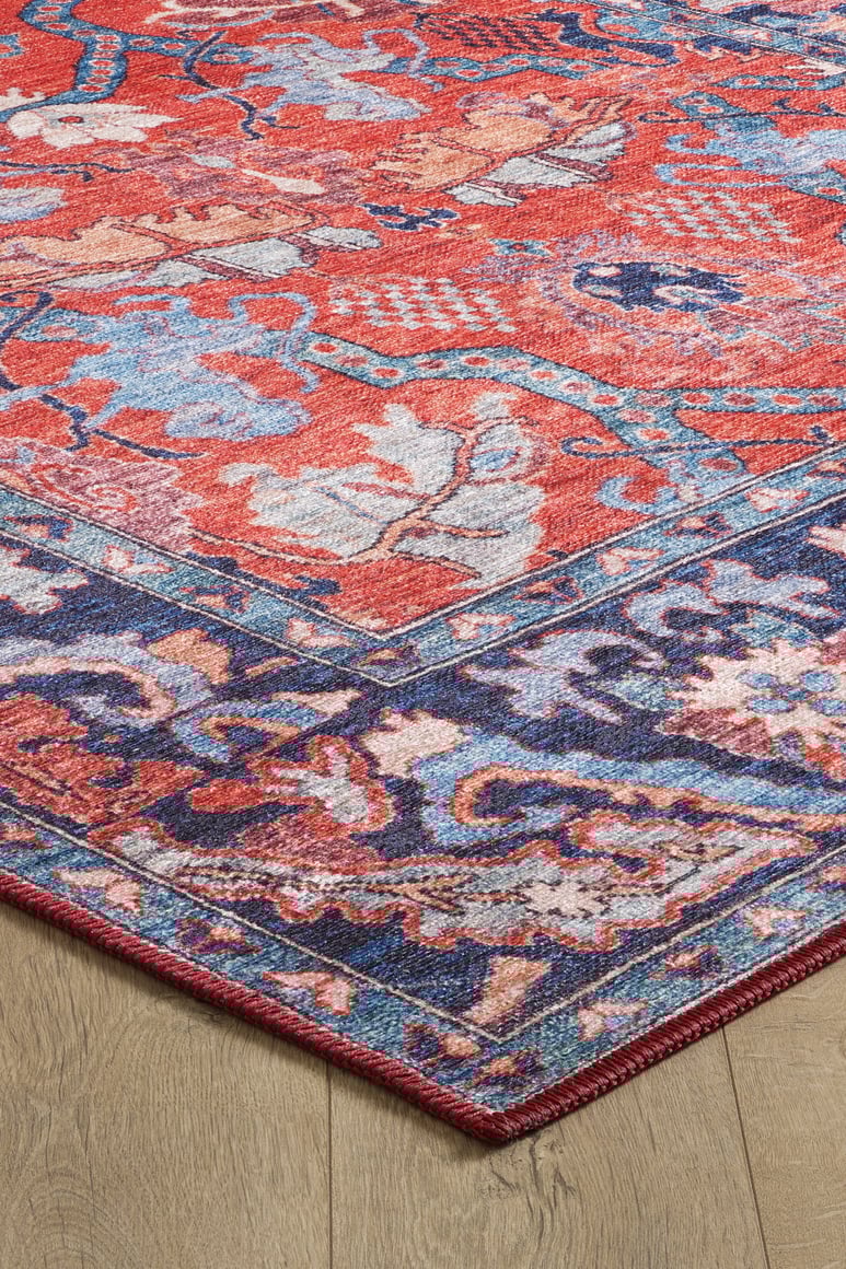A close-up of the Galea Turkish-Design Coral Washable Rug (LCC3027, Custom Size) shows its intricate red, blue, purple, and beige patterns with a detailed border and floral-inspired designs—perfect for high-traffic spaces on wood floors.