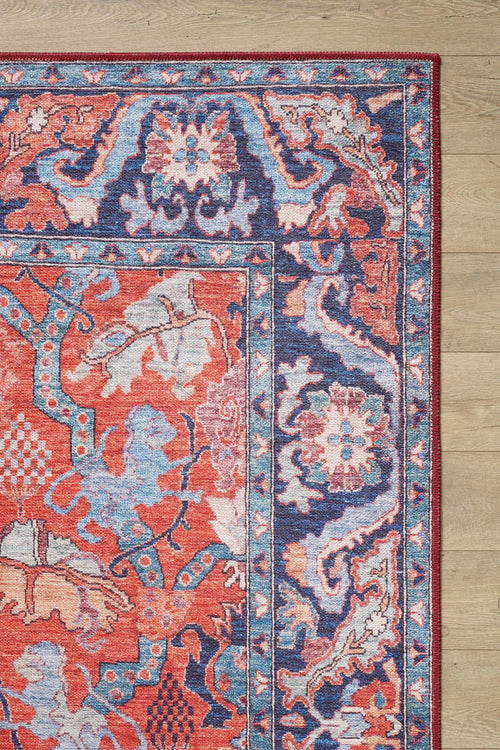 Load image 1 in gallery view. A close-up of the Galea Turkish-Design Coral Washable Rug (LCC3027, Custom Size) with vibrant floral and geometric patterns in red, blue, pink, and cream—ideal for high-traffic areas—shown on light wood flooring.