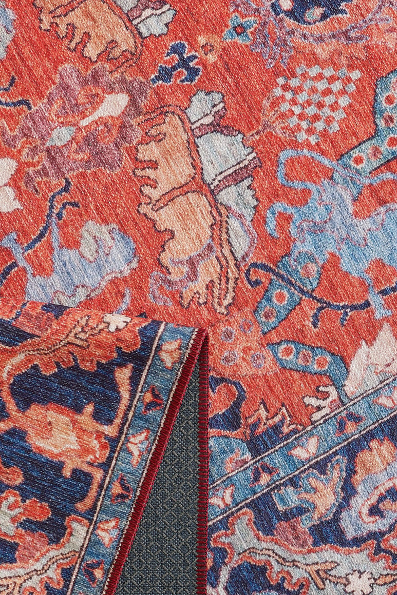 Close-up of the Galea Turkish-Design Coral Washable Rug - LCC3027 (Custom Size) featuring vibrant red, blue, and beige floral and abstract patterns. A folded corner displays the durable textured weave—perfect for high-traffic areas.
