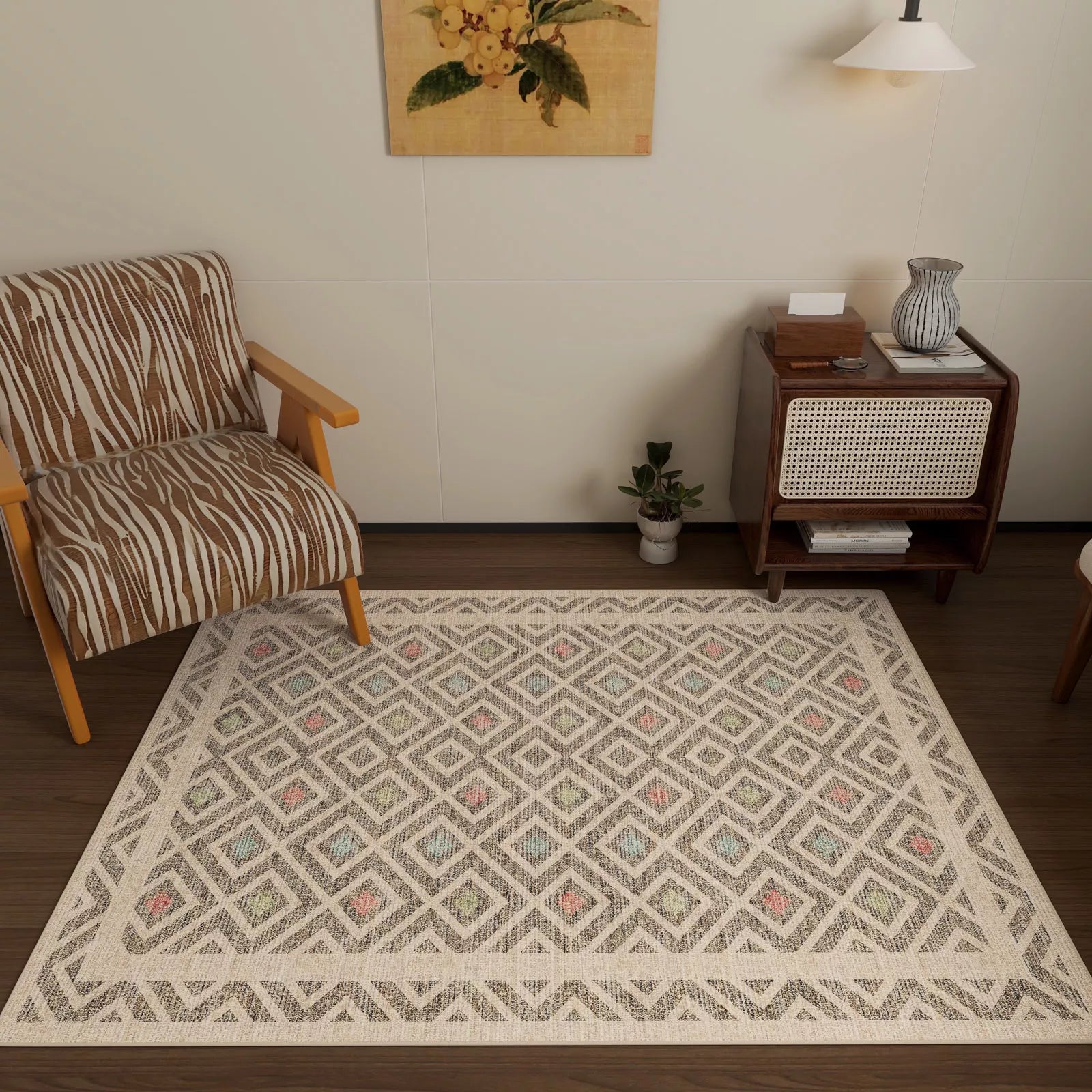 A cozy living room with a brown striped armchair, the Geo Sand Washable Rug (JRN1027), a mid-century side table with books and a vase, a small plant, wall lamp, and a floral painting on a cream wall.