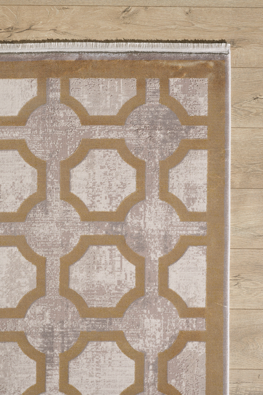 The Geometric Down Mid Century Modern Rug - M534B features a beige and taupe lattice pattern with interlocking shapes and fringe on the short edge, bringing modern style to any light wooden floor.