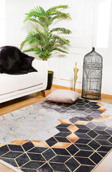 A modern living room featuring the Geometric Harmony - Washable Rug - JR1271 (Custom Size) in gray-anthracite, a white sofa with a black fur throw, a potted green plant, gold cobra decor, an empty black birdcage, and a beige floor cushion.
