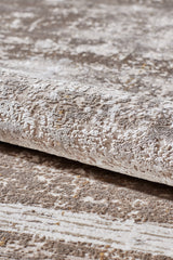 A close-up view of the Geometric Latte Premium Rug - M420G, a modern, machine-made rug in light beige and gray with a subtle abstract pattern and minimalist design.