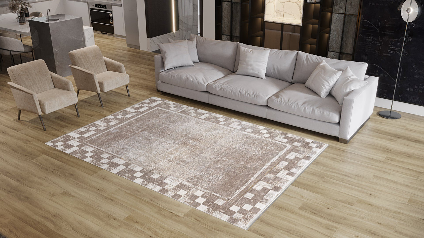 A modern living room with light wood floors, a Geometric Latte Premium Rug - M420G, a long gray sofa with cushions, two beige armchairs, and a floor lamp in the corner near a dark accent wall.