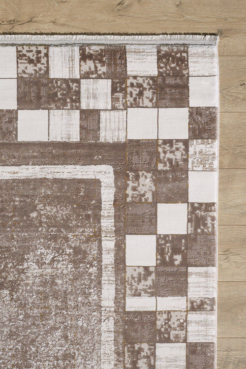 Load image 1 in gallery view. A close-up of the Geometric Latte Premium Rug - M420G shows its brown and white square border on a light wooden floor. This machine-made rug features a textured center, ideal for minimalist interiors.