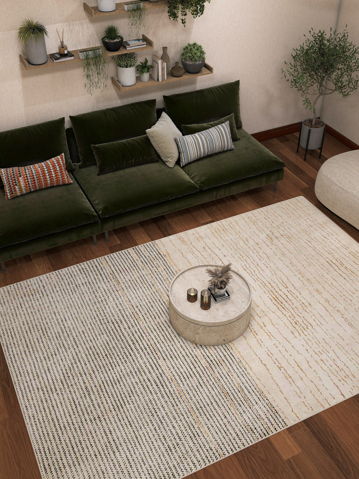 A cozy living room with a green velvet sofa, decorative pillows, a round stone coffee table, and the Gilded Charm - Washable Rug - JRN26 (Custom Size), perfect for high-traffic areas. Wall shelves with plants and a potted tree add natural charm.