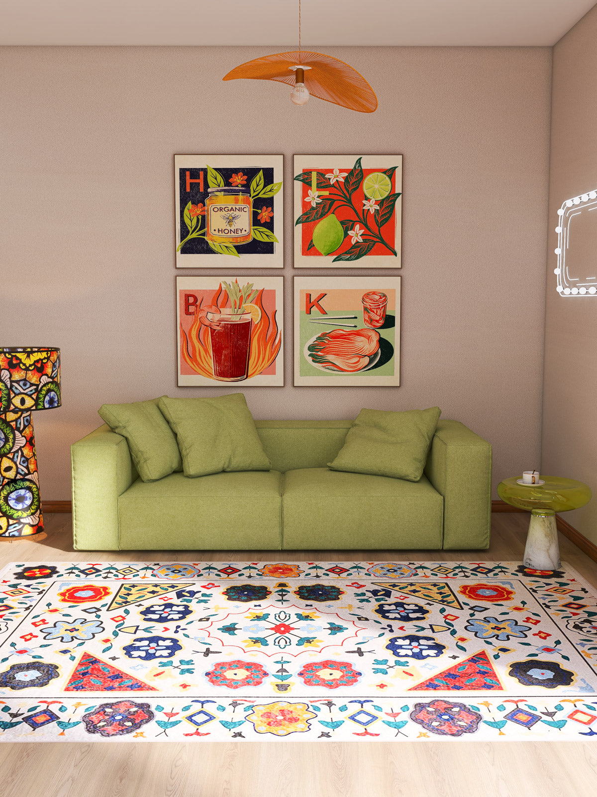 A modern living room with a green sofa, Global Gathering - Washable Rug - JR608 for high-traffic areas, small round side table, four vibrant food-themed art prints above the sofa, and a decorative lamp to the left.