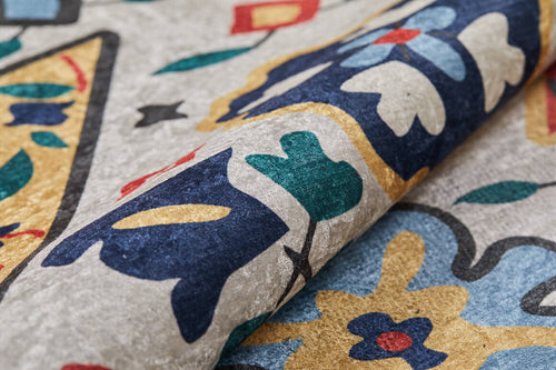 Load image 1 in gallery view. Close-up of the Global Gathering - Washable Rug - JR608 (Custom Size), rolled to display its blue, yellow, green, red, and ivory floral and geometric pattern on a textured light gray background—ideal for high-traffic areas.