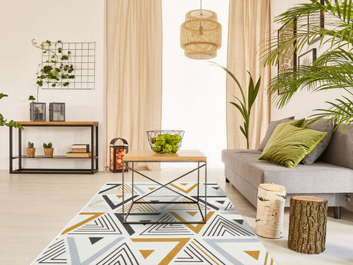 Load image 1 in gallery view. A modern living room features a gray sofa, green cushions, a wooden coffee table, and the Golden Fog - Washable Double-Sided Kilims - AR18. Indoor plants and beige curtains complete the space with natural wood and metal accents for warmth.