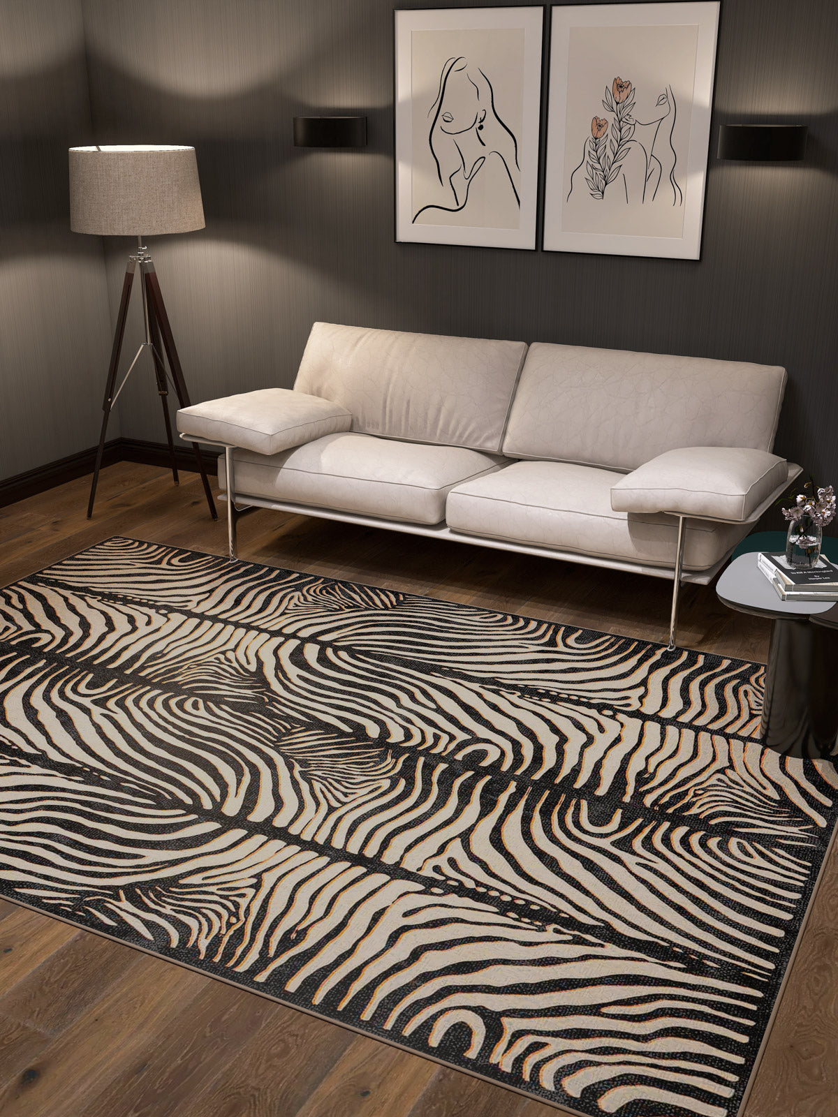 A modern living room with a beige sofa, tripod floor lamp, and two abstract prints features the Gossamer Fade - Washable Rug - JRN44. Its stylish design and washable material make it perfect for high-traffic, allergy-friendly spaces.
