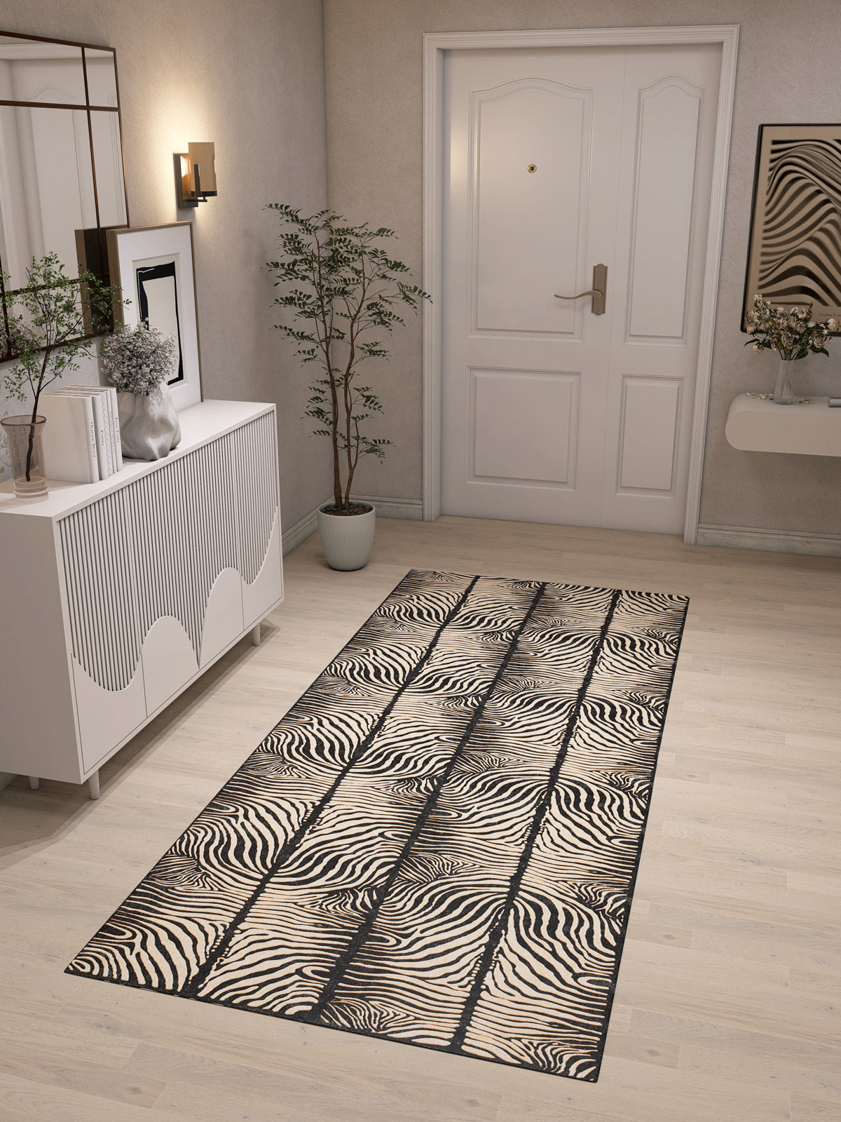 A modern entryway with light wood floors, white walls, a white door, a potted plant, a white cabinet, wall art, and the Gossamer Fade - Washable Rug - JRN44—ideal for high-traffic and allergy-sensitive homes.