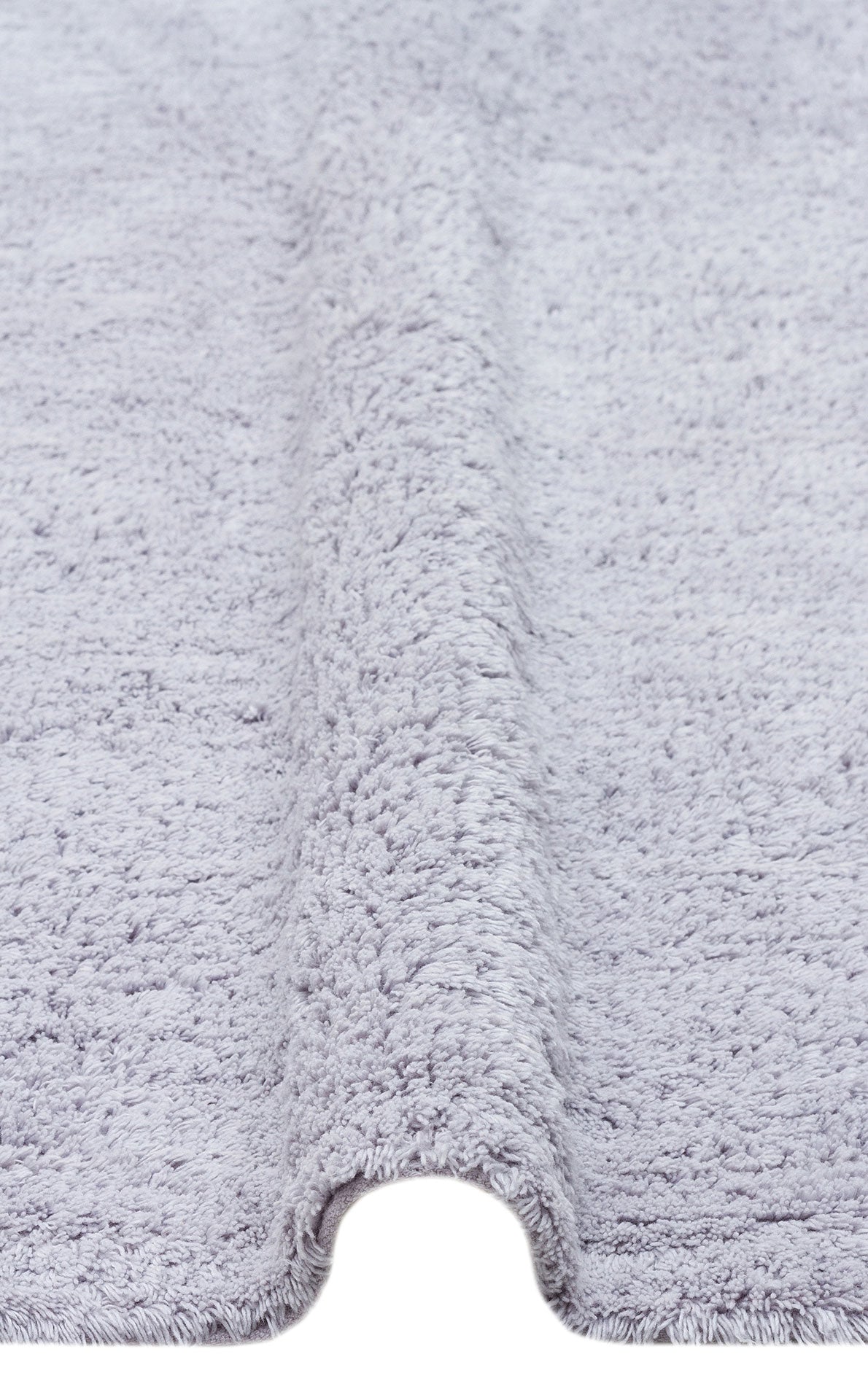 Close-up of the Grey Snug - Washable Shaggy - CBNPLAIN rug in light gray, featuring a soft, plush texture and a visible raised fold running vertically through the center.