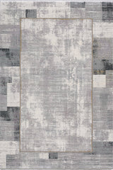 The GridWave Silver Premium Rug - M426A is a modern machine-made piece with a distressed abstract patchwork in shades of gray, white, and black, highlighted by a subtle golden rectangle near the center.