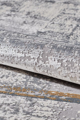 A detailed view of the GridWave Silver Premium Rug - M426A reveals its soft acrylic-viscose blend with an abstract gray, beige, and gold pattern. The rug’s textured surface combines raised and flat areas for a modern, distressed effect.