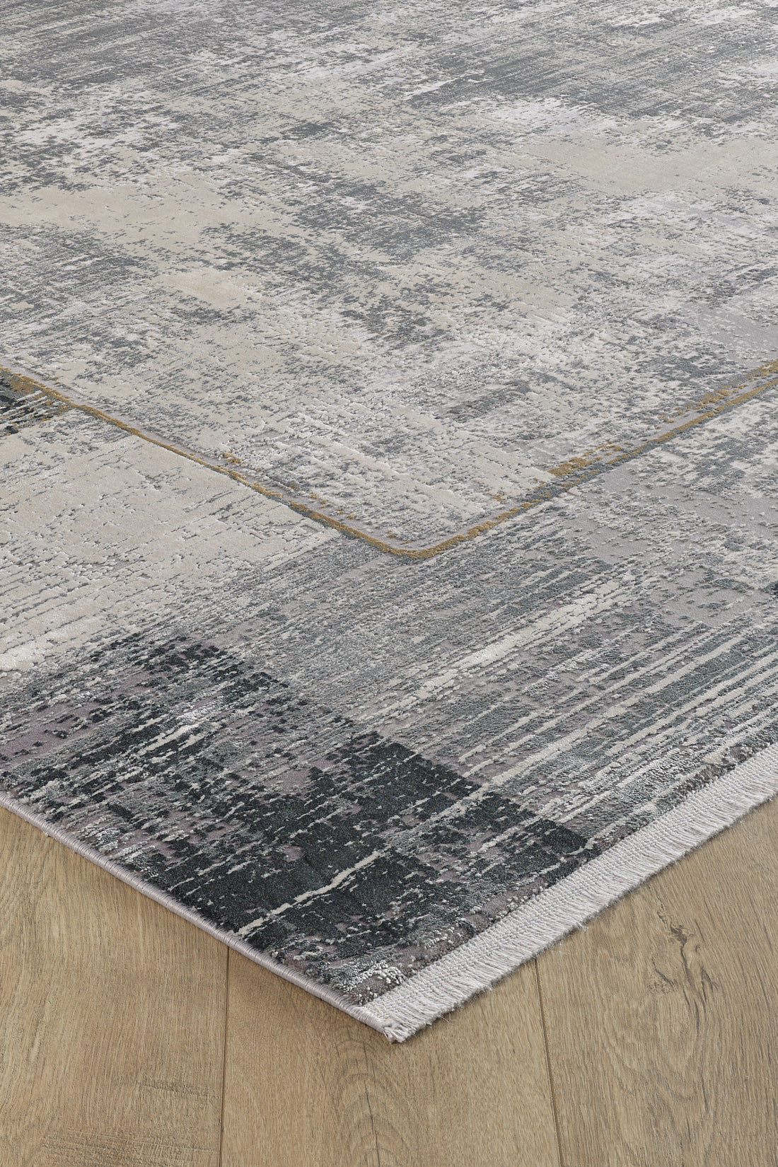 A close-up of the GridWave Silver Premium Rug - M426A, featuring a textured, abstract gray and beige pattern on a light wooden floor. This machine-made rug offers a modern minimalist look with neat edges and a slightly distressed finish.