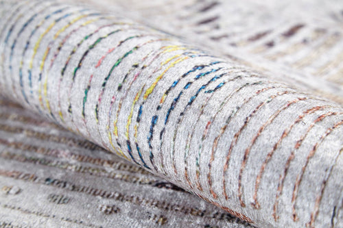 Load image 1 in gallery view. A close-up of the Gypsy Glam - Washable Rug - JR1716 (Custom Size), showcasing its soft, plush white and gray base with colorful curved and straight stitched lines in yellow, blue, green, orange, and brown.