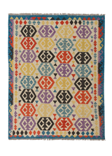 The Handcrafted Story - Handwoven Kilim is a vibrant flatweave rug with geometric hexagons in red, yellow, blue, purple, and black on a light base. Its border features classic blue, red, and black zigzag patterns typical of kilims.