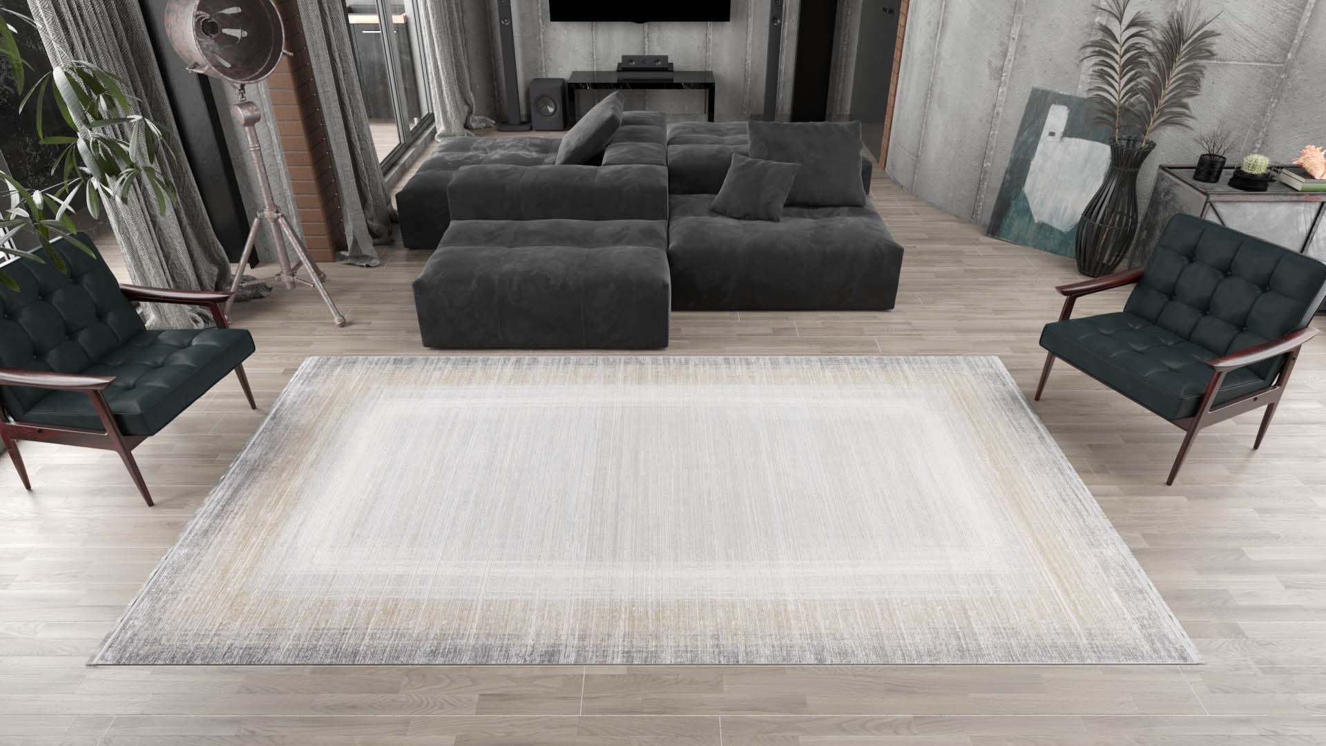 A modern living room with a gray sectional, dark green armchairs, wood floors, and industrial decor—like exposed brick and a tripod lamp—is anchored by the Harmony in Contours Modern Bordered Rug - EW5743 in light tones.