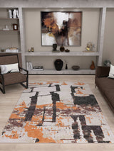 A modern living room with a brown sofa, black armchair, abstract art above a gray shelf, and the Heirloom Touch - Washable Rug - JRN42 in orange, beige, and black on light wood floors—perfect for stylish modern spaces.