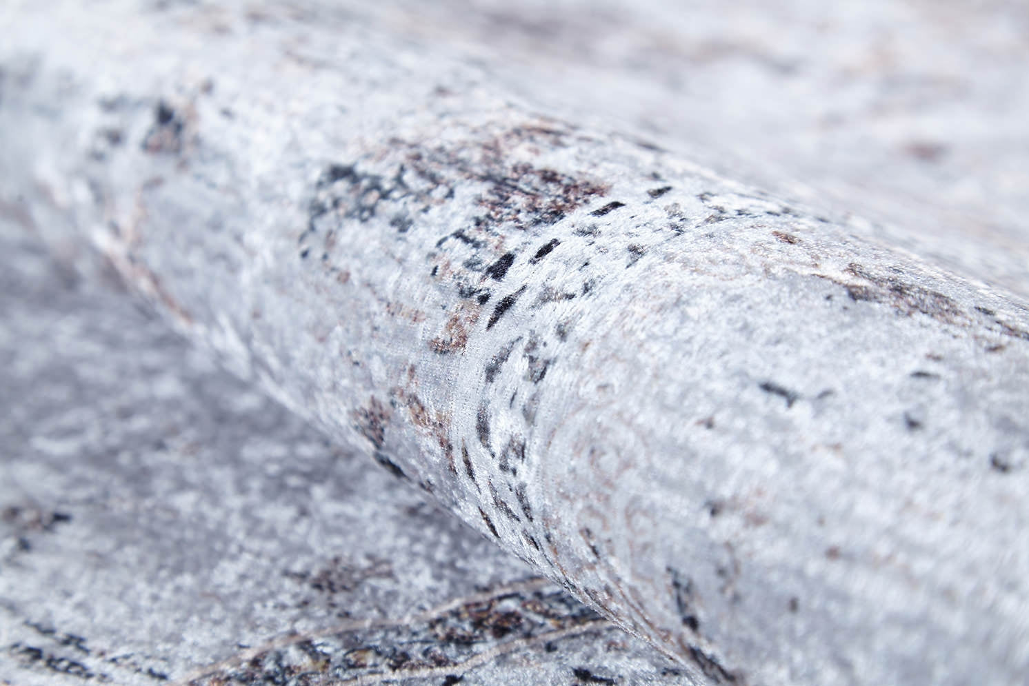 A close-up of the Heritage Jewel - Washable Rug - JR1778 (Custom Size), featuring a light gray and white marbled pattern with subtle brown hints and dark specks—durable, easy-to-clean, and perfect for high-traffic areas.