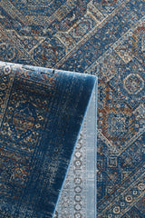 The Hidden Treasures Turkish Rug - Azure - 2223B features intricate blue and beige geometric and floral patterns, with a folded corner displaying the detailed underside.