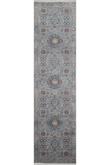 The Hidden Treasures Turkish Rug - Smoky - 2223C is a rectangular, narrow runner featuring intricate geometric and floral designs in blue, gray, and rust tones for a sophisticated look.
