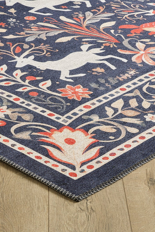 Load image 1 in gallery view. A close-up of the Holiday Heart Washable Area Rug - MDJ001, featuring a dark blue background with white animal silhouettes, orange and beige floral patterns, and a stitched edge—ideal for high-traffic areas on light wood floors.