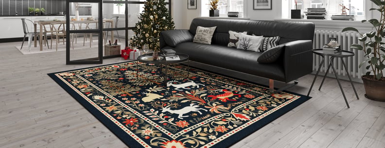 A modern living room with light wood floors, a black sofa, the Holiday Heart Washable Area Rug - MDJ001 featuring animal and floral motifs ideal for high-traffic areas, a decorated Christmas tree, and a dining area in the background.
