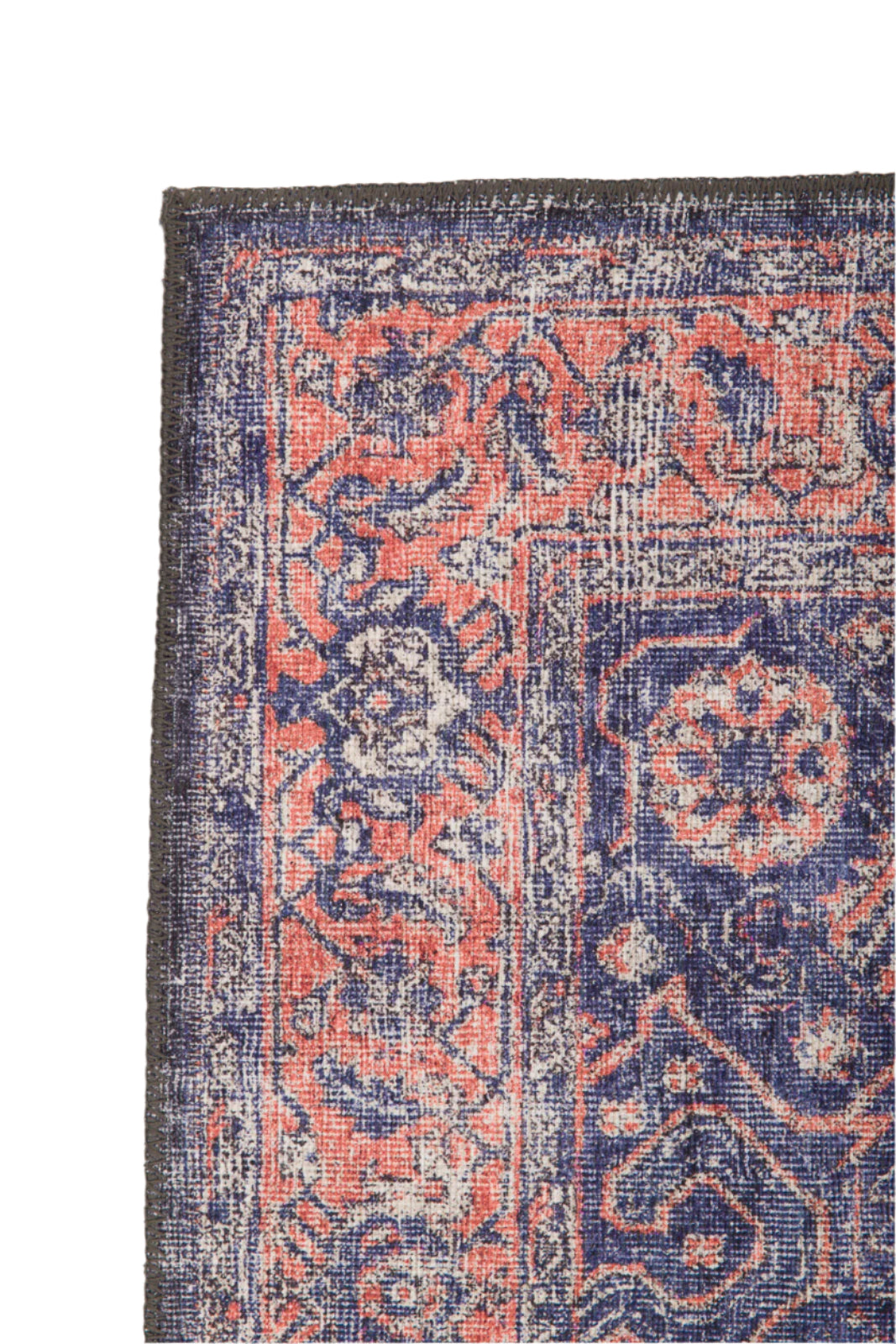 A close-up of the Stormstripe Echo - Washable Rug (JR0046) highlights its intricate floral patterns in navy blue, coral, and white tones, accented by a dark border and detailed decorative designs, all in a washable format.