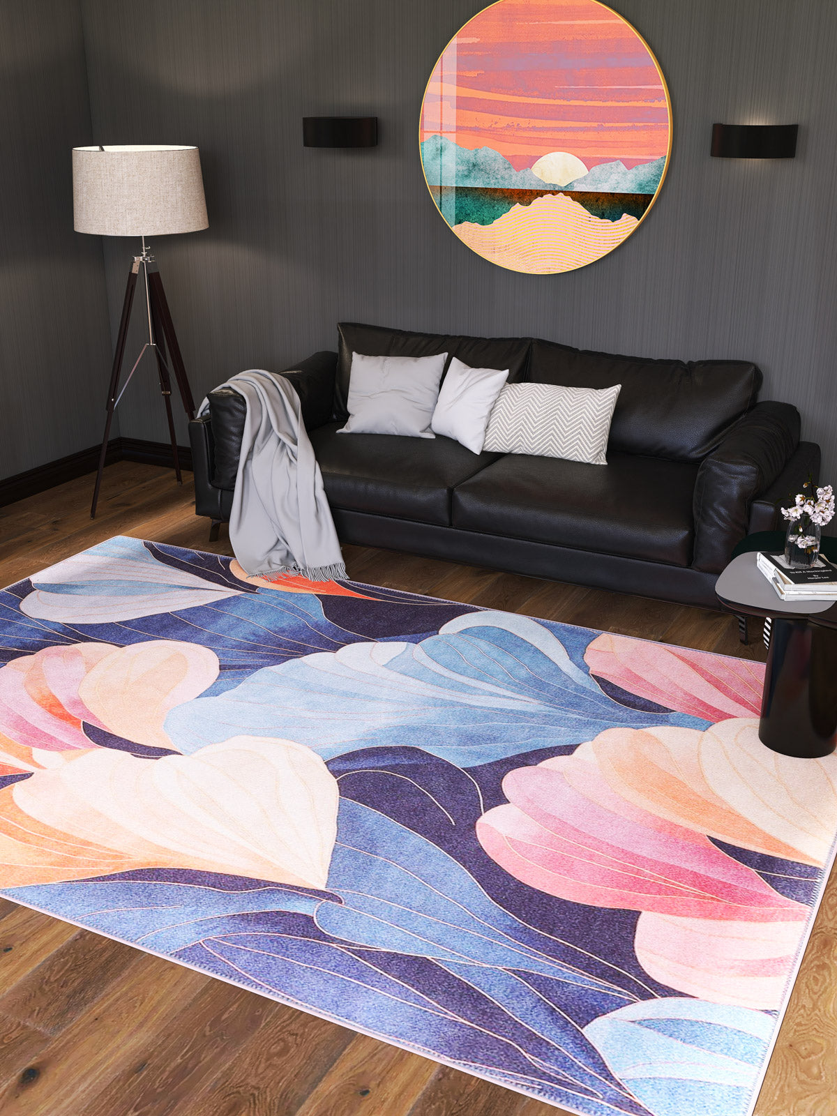 A modern living room with a black sofa, floor lamp, side table, and the Iris Abstract Floral Washable Rug - MDJ009 (Custom Size)—ideal for high-traffic areas. A round, vibrant landscape artwork hangs on the dark wall above the sofa.