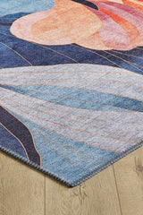 A close-up of the Iris Abstract Floral Washable Rug - MDJ009 (Custom Size) shows its blue, gray, and peach wave patterns on a light wood floor. Durable for high-traffic areas, the detailed edge stitching is clearly visible.