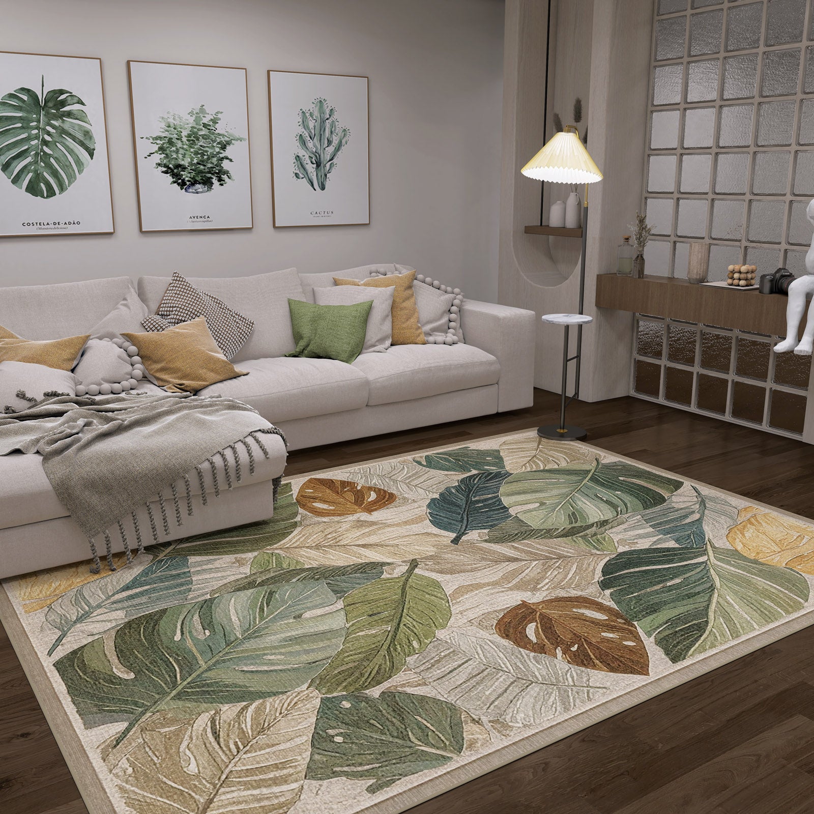 A cozy living room with a white sofa, green and yellow cushions, the Amazon Veil - Washable Rug - JRS010 in a leafy pattern—ideal for busy areas—botanical wall art, a standing lamp, and modern decor in warm earthy tones.