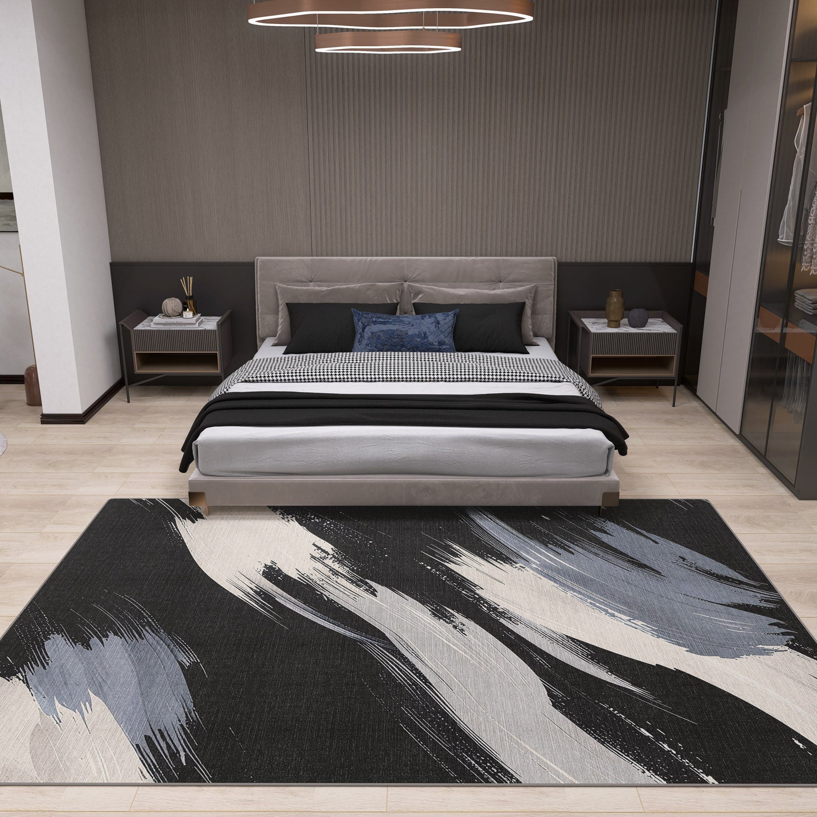 A modern bedroom with a gray upholstered bed, black and white bedding, nightstands, and the Shadow Flow - Washable Rug - JRS011 in black, white, and gray on light wood floors—ideal for high-traffic areas. A circular ceiling light is above the bed.