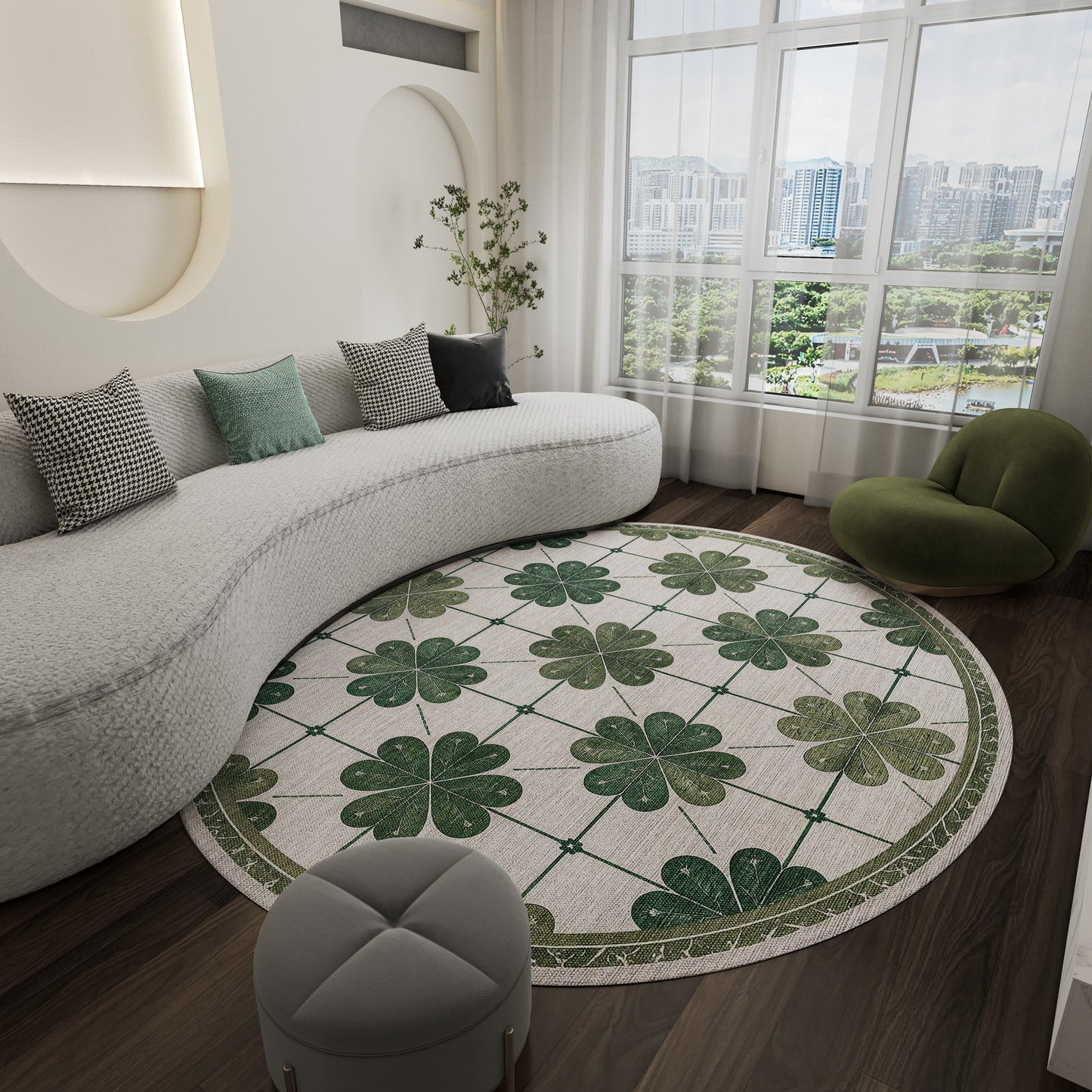 A modern living room featuring a curved white sofa, the Emerald Charm - Washable Rug - JRS013 with a green clover pattern for high-traffic areas, small gray ottoman, green lounge chair, and large window overlooking city buildings and trees.