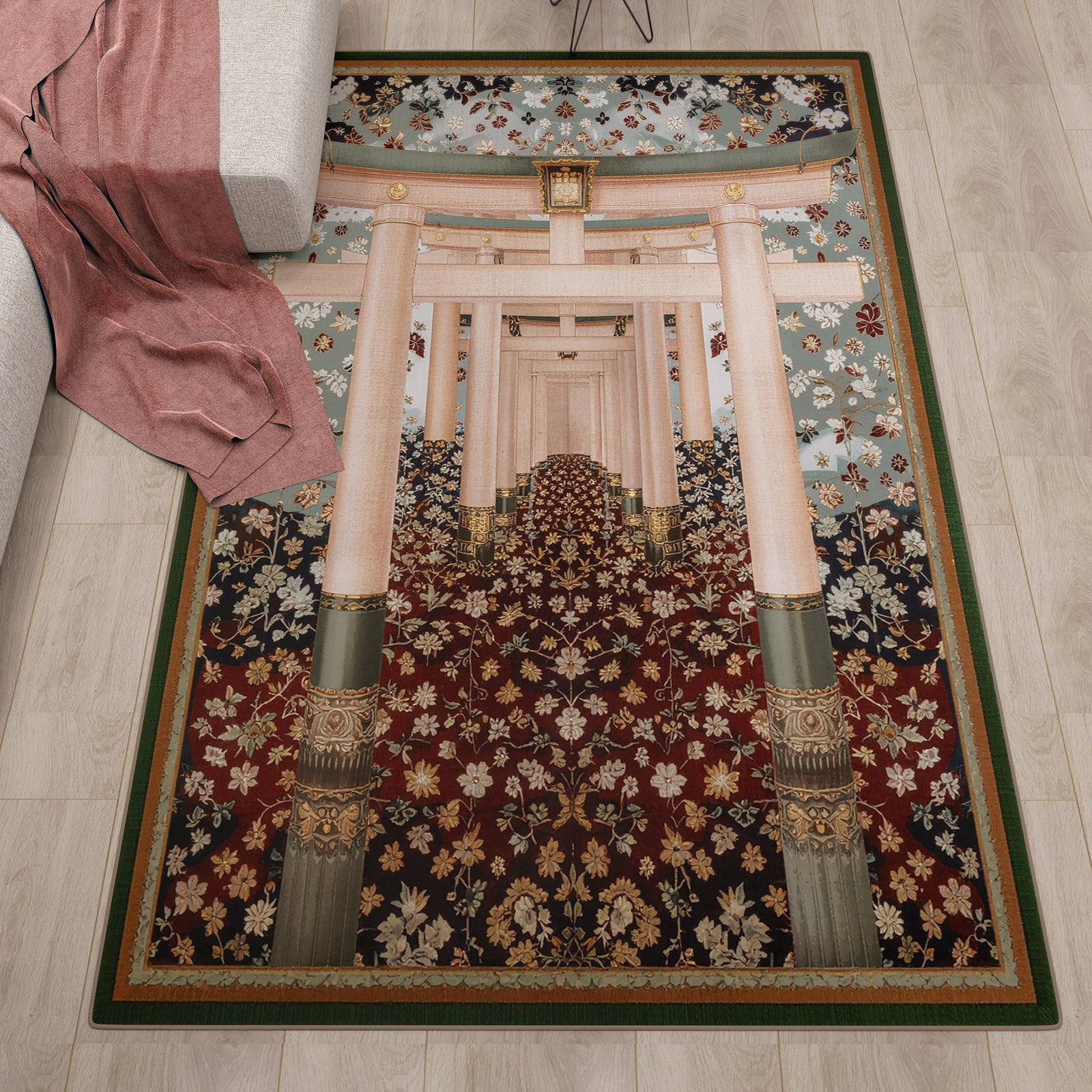 The Blossom Path - Washable Rug - JRS021, featuring intricate torii gates and floral patterns, lies beside a gray sofa with a pink blanket. Its design adds charm to contemporary spaces with light wood floors.