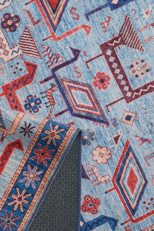 Load image 1 in gallery view. The Birdwatcher's Dream Blue Washable Rug - LCC3020 features geometric and floral patterns in red, blue, and cream. A folded corner reveals a blue and orange star design on the back—perfect for high-traffic areas.
