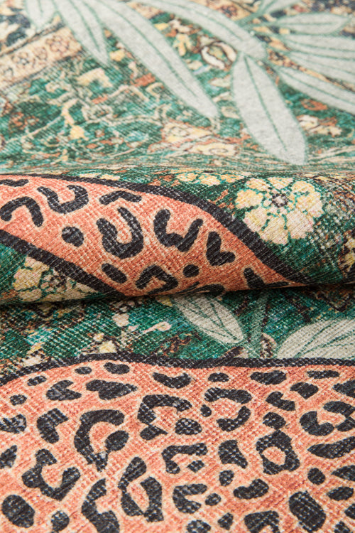 Bild 1 in Galerieansicht laden. Close-up of the Jungle Ember - Washable Rug (JR0047) shows its woven, washable texture with green leafy patterns and orange sections with black leopard spots—highlighting the rug’s vibrant detail and design.