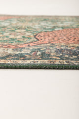 Close-up of the Jungle Ember Washable Rug (JR0047) laying flat on a light surface, highlighting its intricate geometric pattern in green, red, and beige.