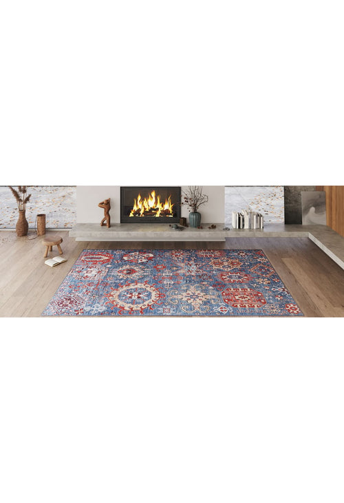 Load image 1 in gallery view. A cozy living room with a lit fireplace, modern decor, and the Kaleidos Authentic Blue Washable Rug - LCC3028 (Custom Size) featuring colorful patterns on a light wooden floor—ideal for high-traffic spaces. Decorative vases and sculptures line the mantel.