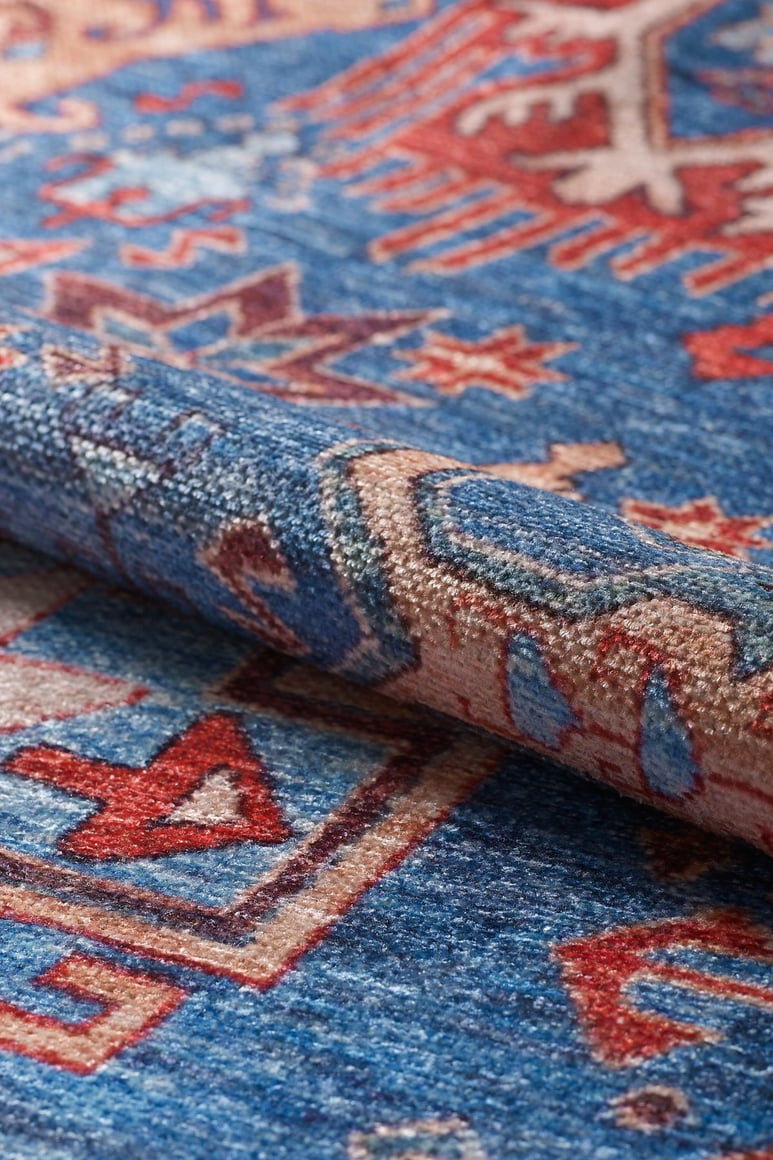 A close-up of the Kaleidos Authentic Blue Washable Rug - LCC3028 (Custom Size) highlights its red, white, and beige geometric patterns and textured surface—washable and perfect for high-traffic areas.