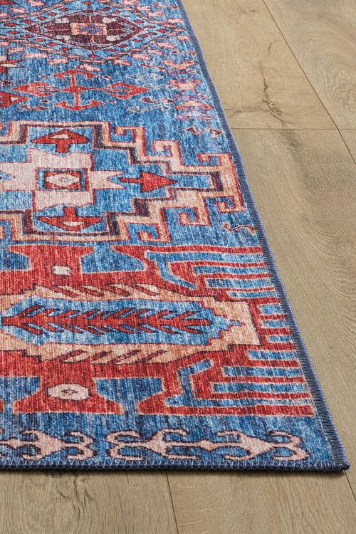 Load image 1 in gallery view. The Kaleidos Authentic Blue Washable Rug - LCC3028 (Custom Size) features intricate geometric patterns in blue, red, white, and pink. Shown on a light wood floor, it’s ideal for high-traffic areas and highlights its unique design and washable texture.