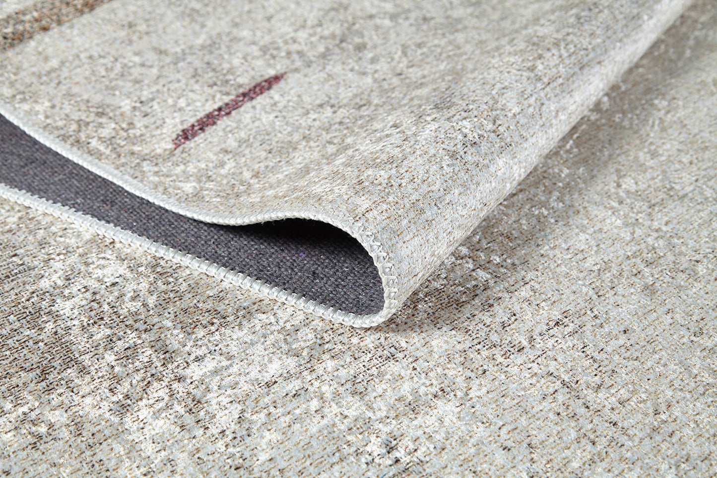A close-up of the Kaleidoscope Dreams - Washable Rug - JR5055 (Custom Size) in beige and brown with a folded corner, highlighting its woven texture and detailed edging—perfect for high-traffic or allergy-sensitive spaces.